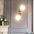 Applique da parete metallo oro con 2 sfere in vetro bianco attacco G9 lampada design moderno minimal